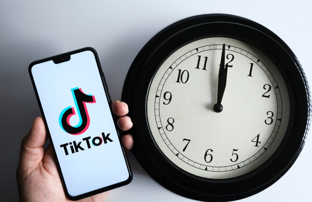 TikTok on a smartphone with a clock close to midnight